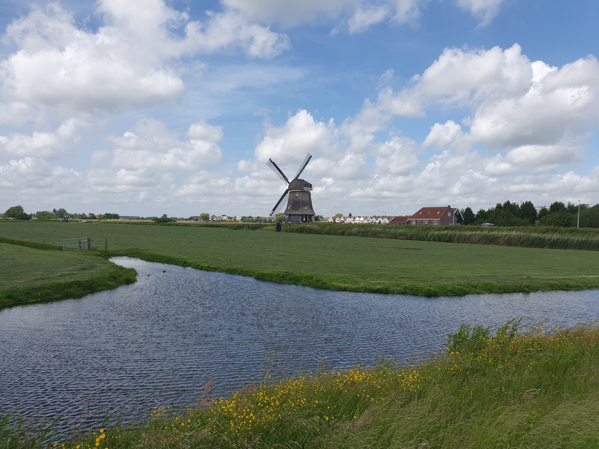 A wind mill at a ditch, with Volendam in the background